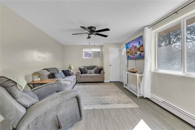 living room with a baseboard heating unit, ceiling fan, and hardwood / wood-style floors