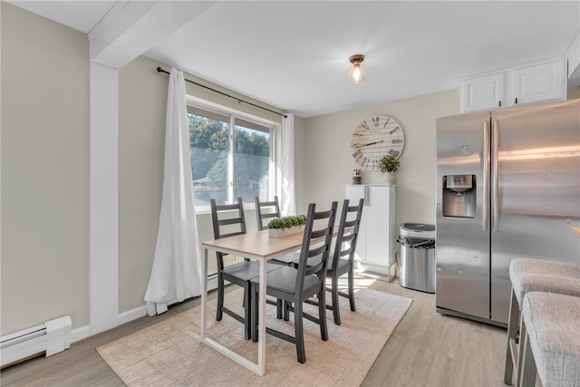 dining area featuring a baseboard radiator and light hardwood / wood-style flooring