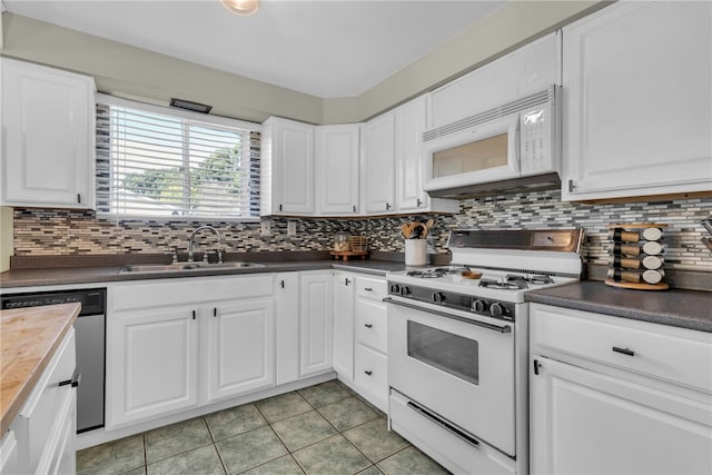 kitchen featuring white cabinets, backsplash, and white appliances