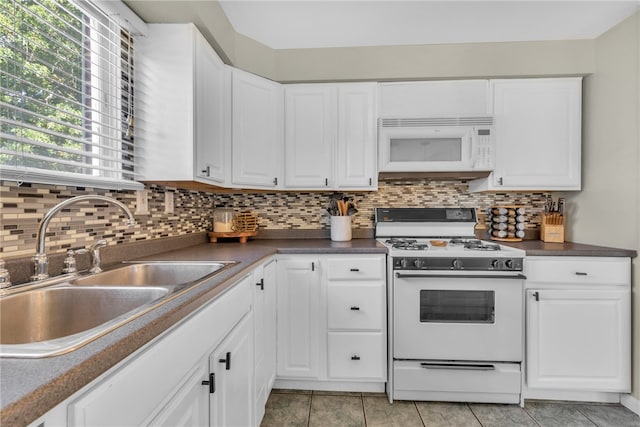 kitchen with light tile patterned floors, sink, white appliances, white cabinetry, and decorative backsplash