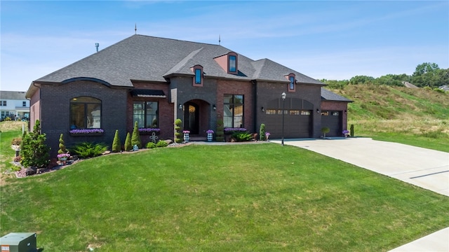 french country home featuring a garage and a front lawn