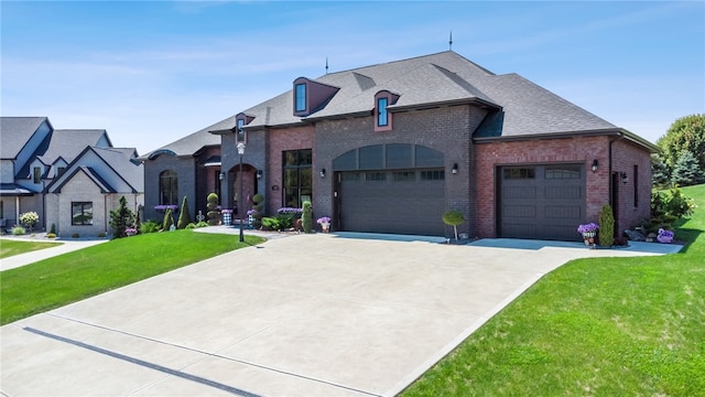 french country home featuring a front yard and a garage