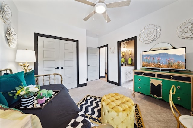 bedroom with light carpet, ceiling fan, ensuite bathroom, and a closet