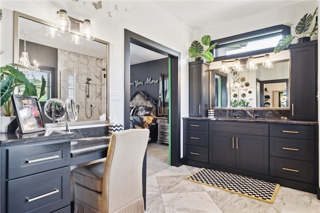 bathroom with a healthy amount of sunlight, a notable chandelier, a shower with door, and vanity