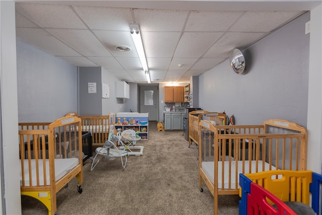 carpeted bedroom with a drop ceiling