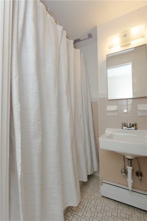 bathroom with a baseboard radiator, tile walls, and tile patterned floors