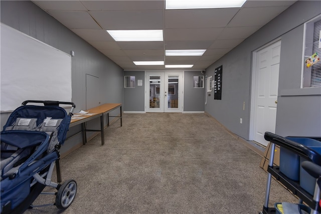 carpeted office with a paneled ceiling