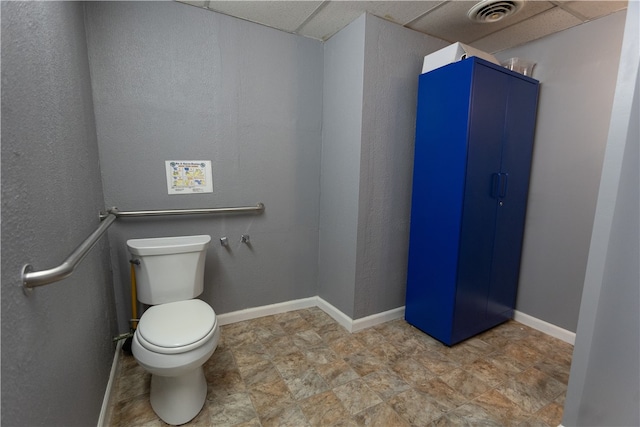 bathroom with a paneled ceiling and toilet