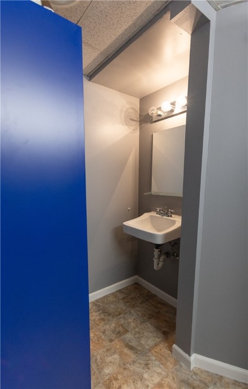 bathroom with a drop ceiling and sink