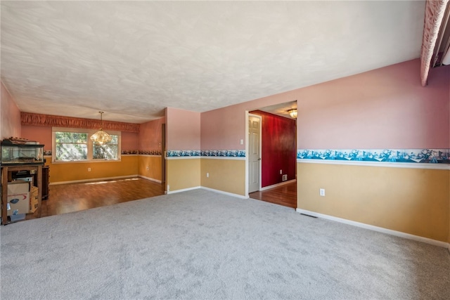 spare room featuring an inviting chandelier and hardwood / wood-style flooring