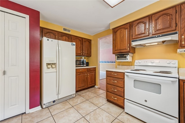 kitchen featuring light tile patterned floors and white appliances