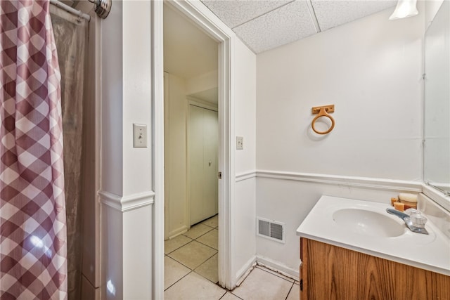 bathroom with vanity, a paneled ceiling, tile patterned flooring, and curtained shower