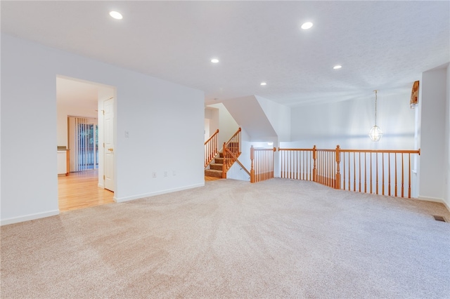 bonus room with an inviting chandelier and light colored carpet