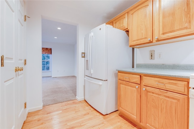 kitchen featuring light brown cabinetry, light hardwood / wood-style flooring, and white refrigerator with ice dispenser