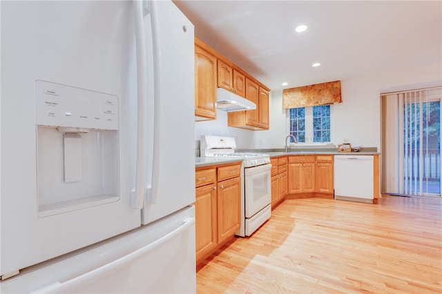 kitchen with light wood-type flooring, white appliances, and light brown cabinets