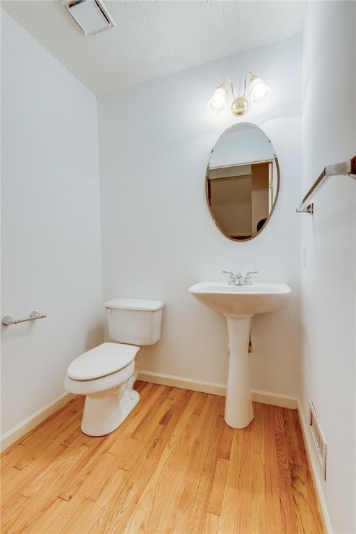 bathroom with hardwood / wood-style floors and toilet