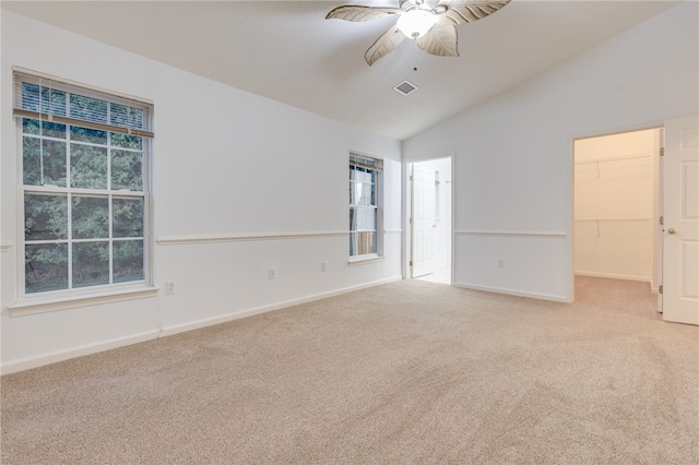 spare room with ceiling fan, lofted ceiling, and light carpet