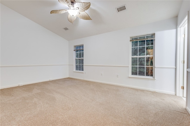 carpeted spare room featuring vaulted ceiling, a wealth of natural light, and ceiling fan