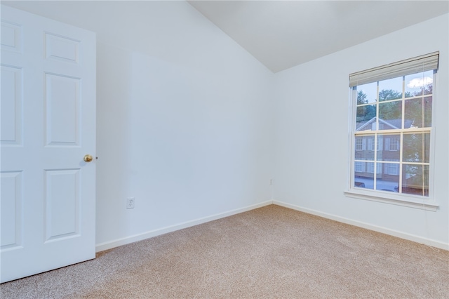 empty room with lofted ceiling and light colored carpet