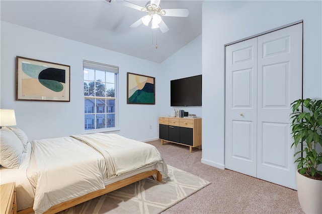 carpeted bedroom with ceiling fan, a closet, and vaulted ceiling