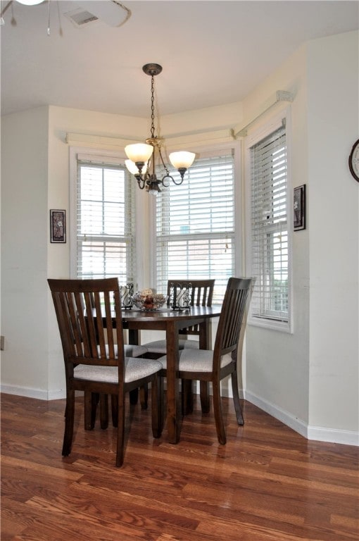 dining space with an inviting chandelier and dark hardwood / wood-style floors