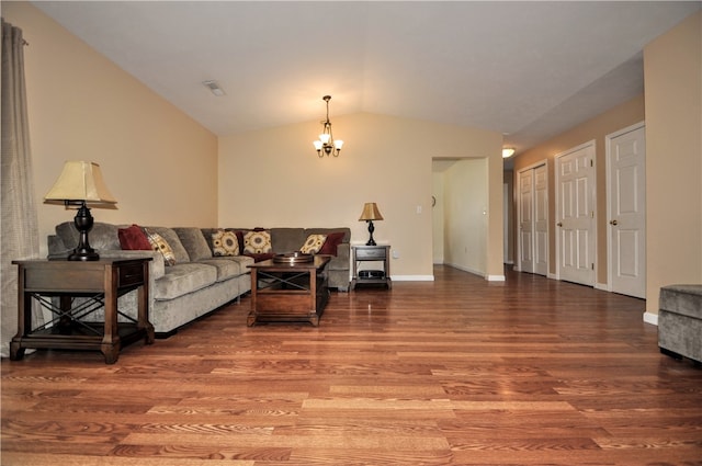 living room featuring hardwood / wood-style flooring, lofted ceiling, and a chandelier