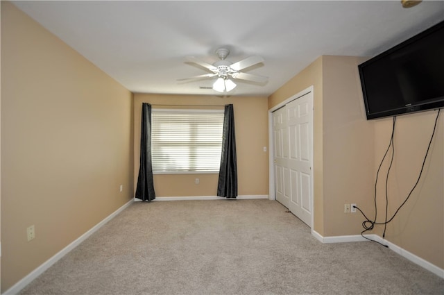 unfurnished bedroom with a closet, ceiling fan, and light colored carpet