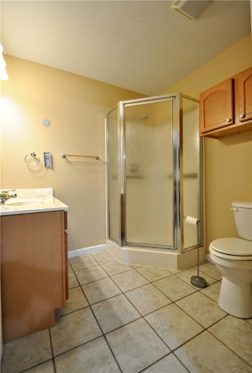 bathroom featuring tile patterned flooring, a textured ceiling, a shower with door, vanity, and toilet