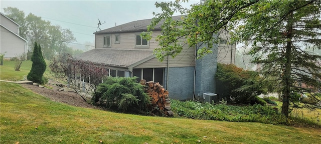 view of property exterior with a lawn and central air condition unit