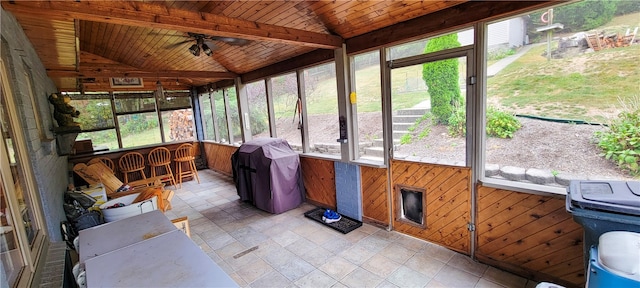 sunroom / solarium with vaulted ceiling with beams, wood ceiling, and ceiling fan