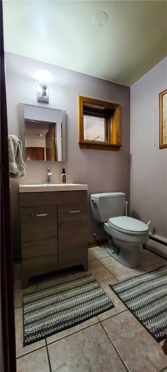 bathroom with a baseboard heating unit, tile patterned floors, vanity, and toilet