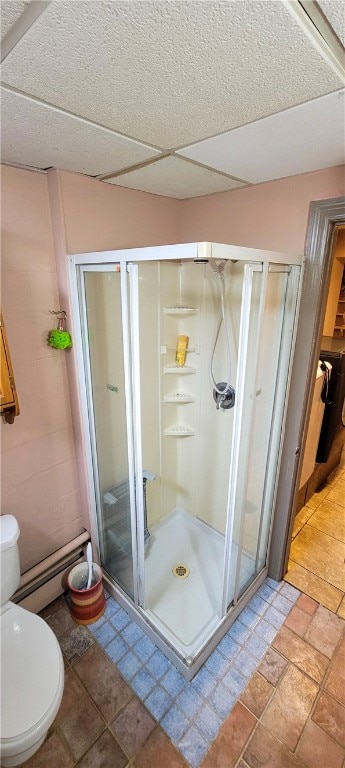 bathroom with walk in shower, baseboard heating, and toilet