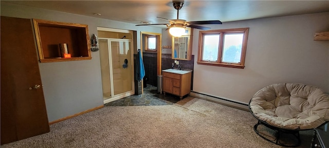 interior space featuring baseboard heating, dark colored carpet, ceiling fan, and sink