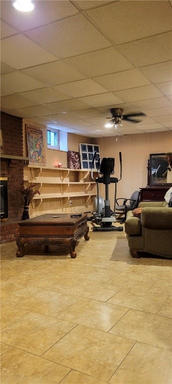 living room featuring a drop ceiling, ceiling fan, and tile patterned floors