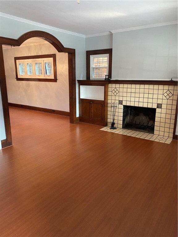 unfurnished living room with hardwood / wood-style flooring, a tiled fireplace, and ornamental molding