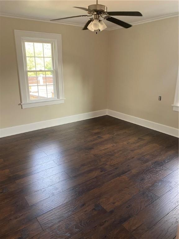 empty room featuring ornamental molding, ceiling fan, and dark hardwood / wood-style floors