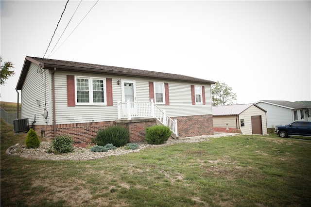 view of front of house with a front yard, an outbuilding, and central air condition unit