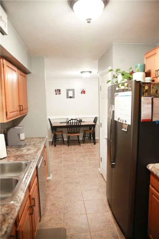 kitchen with sink, light tile patterned floors, and stainless steel appliances