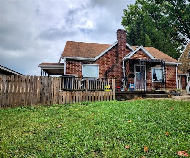 view of front of home with a deck and a front lawn