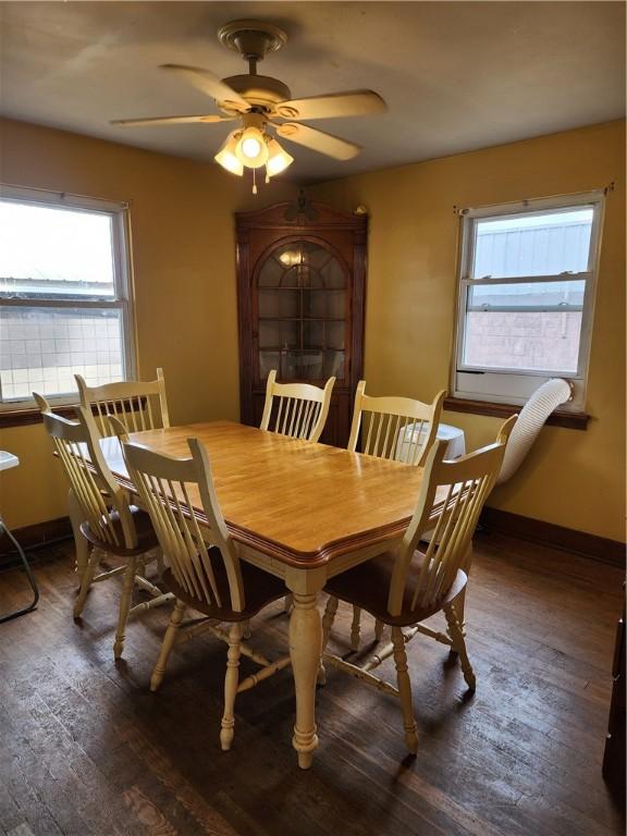 dining area featuring a ceiling fan, baseboards, and dark wood-type flooring