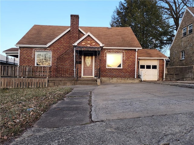 view of front of property with an attached garage, brick siding, a shingled roof, driveway, and a chimney