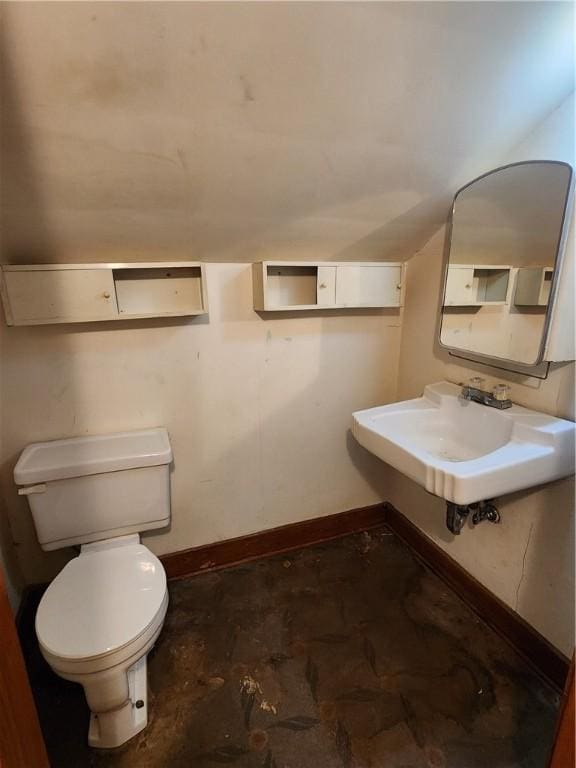 half bathroom featuring toilet, baseboards, and a sink