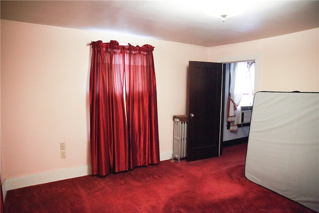 carpeted spare room featuring radiator