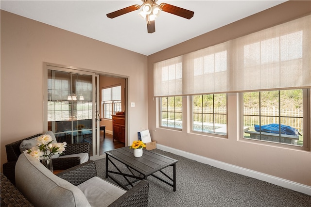 living room featuring ceiling fan and dark carpet