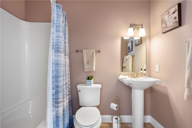 bathroom featuring tile patterned flooring, curtained shower, and toilet