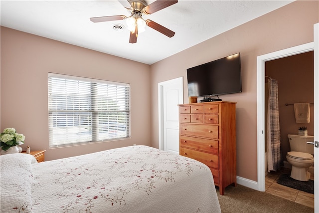 bedroom featuring ceiling fan, light tile patterned floors, and ensuite bathroom