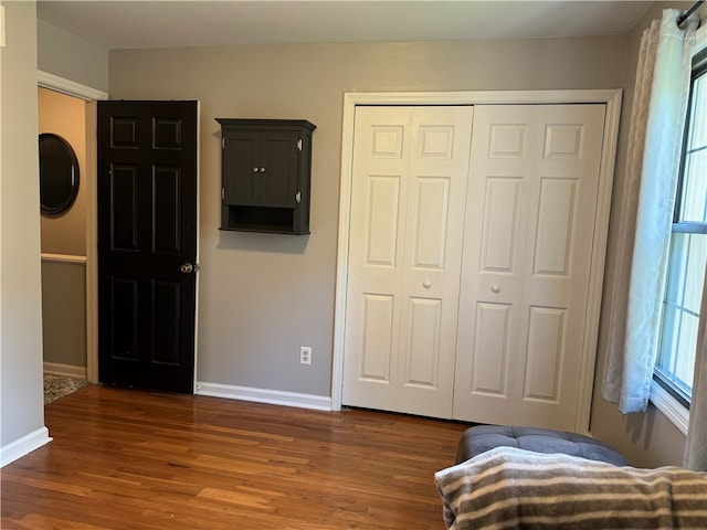 bedroom with dark wood-type flooring and a closet