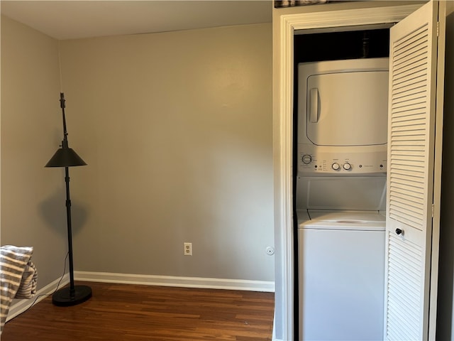 clothes washing area with stacked washer / drying machine and dark hardwood / wood-style flooring