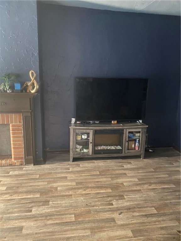 interior details featuring a brick fireplace and hardwood / wood-style flooring