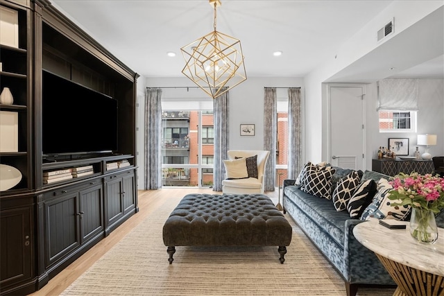 living room with a notable chandelier and light wood-type flooring